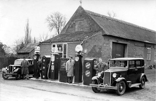 The Manor Garage was originally the barn to the Manor House and still has its
thatched roof.  In the picture above taken in 1936 you can see two previous owners
of the garage, Bill Tidman on the right and Wesley Key on his left.
